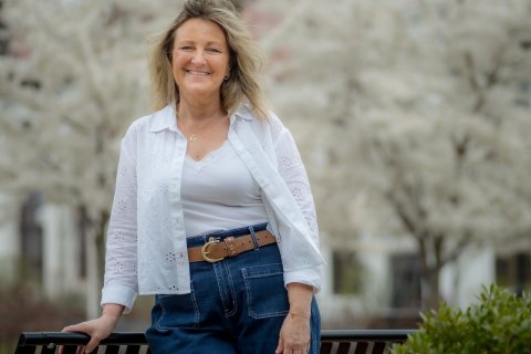 Jodi Cotugno posing in front of a white tree in the background. 