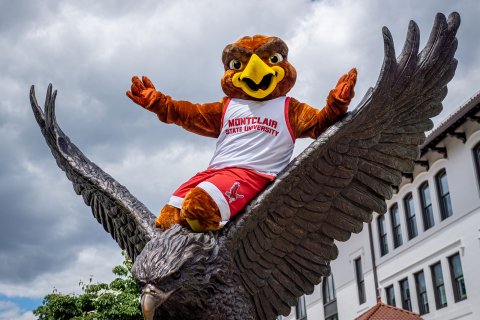 Rocky the Red Hawk sits atop a bronze Red Hawk statue.