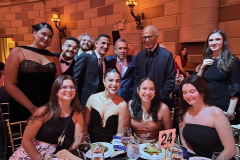 A group of Edward R. Murrow Awards Gala attendees pose at a dining table.