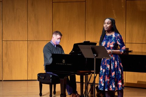 A female student sings while male pianist accompanies.