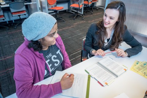 two students chatting and writing