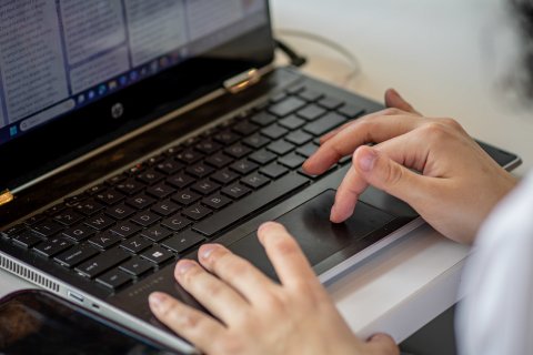 close up of person typing on a laptop