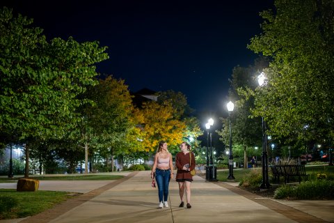 two students walking on campus at night