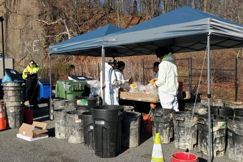 Staff from SCS Engineers as they stand around a sorting table performing a waste audit. 