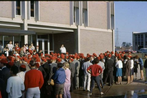 a large crowd of students wearing dink hats