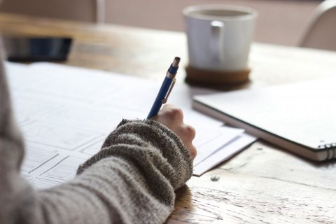 A hand holding a pen and writing