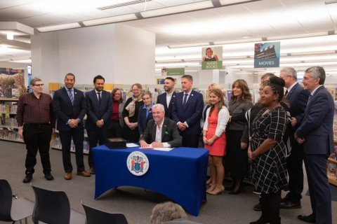 group surrounding governor phil murphy in a library