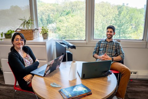 two staff members at a desk with laptops