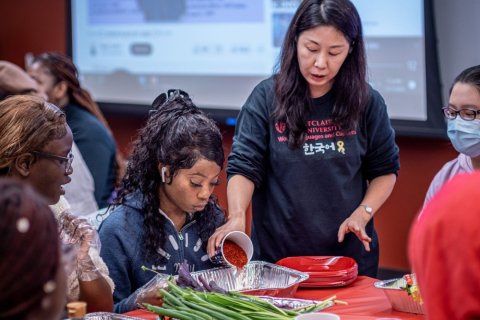Korean Professor Yun Kim demonstrates how to make kimchi to students, faculty and staff at the workshop