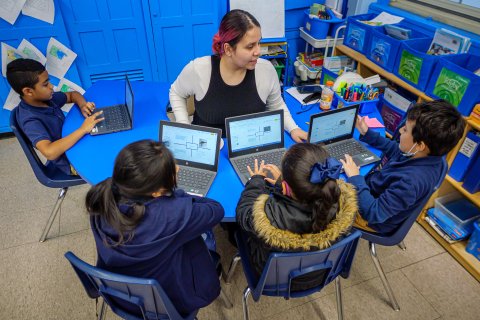 a teacher helps a group of students