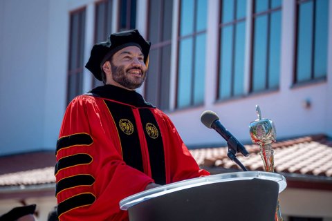 President Koppell at podium in investiture robes and regalia 