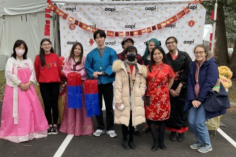 A group of people poses for a photo, with some wearing traditional Korean clothing