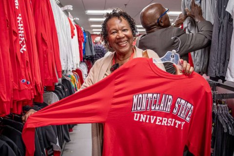alumni holding up a reunion t-shirt