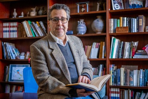 Coccia Director Mark-Rotella seated in a chair in front of bookcases.jpg