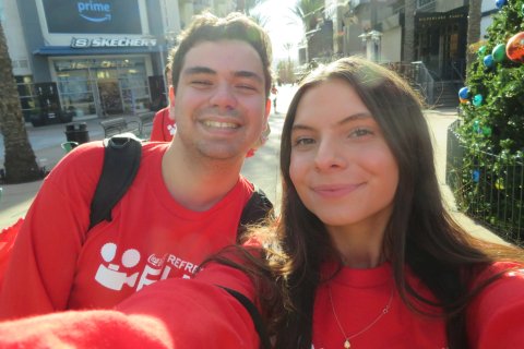 Two students in red shirts smiling in a selfie-style photo.