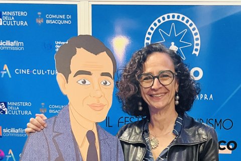 Dr. Teresa Fiore poses with a cartoon-styled cardboard cut-out of film director Frank Capra