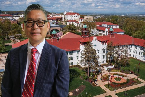 Takeo Suzuk posing in front of a photoshopped building behind him.