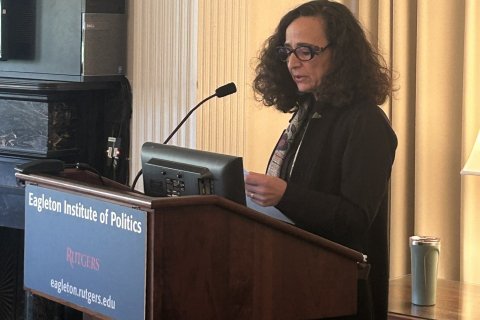 Dr. Teresa Fiore stands at a podium and presents to an audience at Rutgers University