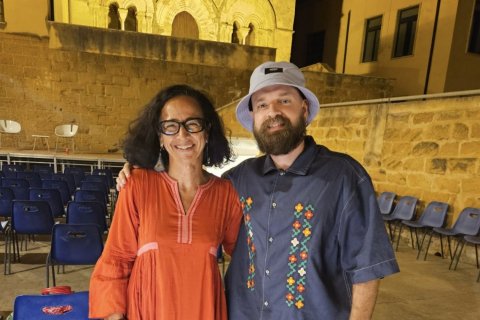 Two people pose at an outdoor auditorium