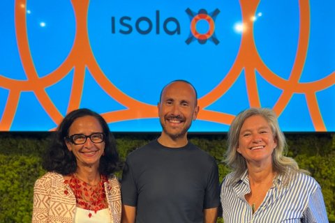 Three people pose in front of a blue and orange background reading "Isola"