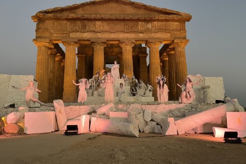 A stage with fake white marble pieces and a Pathenon backdrop