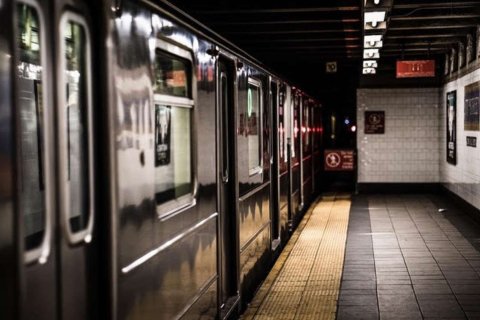 An empty subway platform with a train at the station