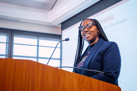 Graduate student presenter speaks at a podium.