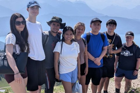 A group of college students pose on a peak in the German Alps