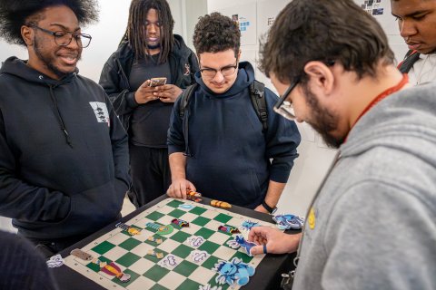 students gather to play a boardgame