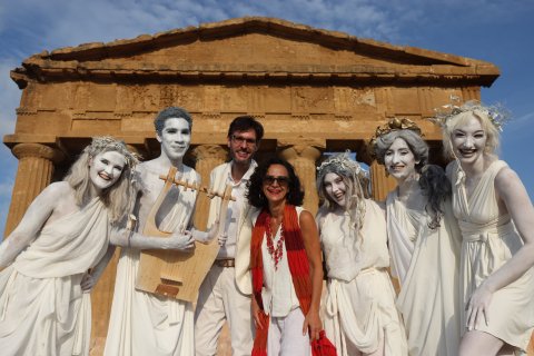 Teresa Fiore and Students pose for photo before a performance. the students are in white clothing with thier bodies painted white