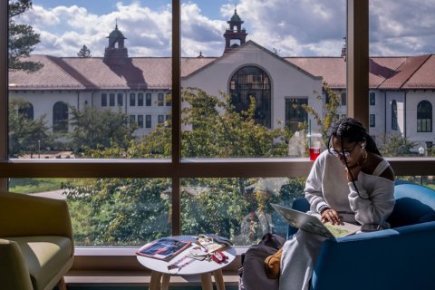 student studying by windows looking over Cole Hall