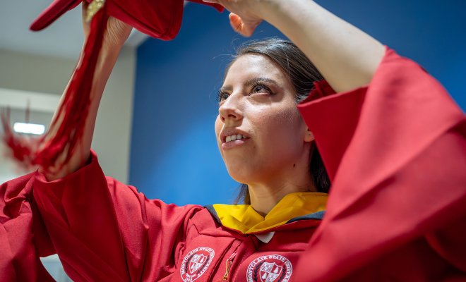 Andrea Uguna-Solano puts on her mortarboard.