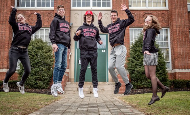 The Povolo quintuplets wear Montclair State University shirts and jump for joy for scholarship offers outside of Passaic Valley High School