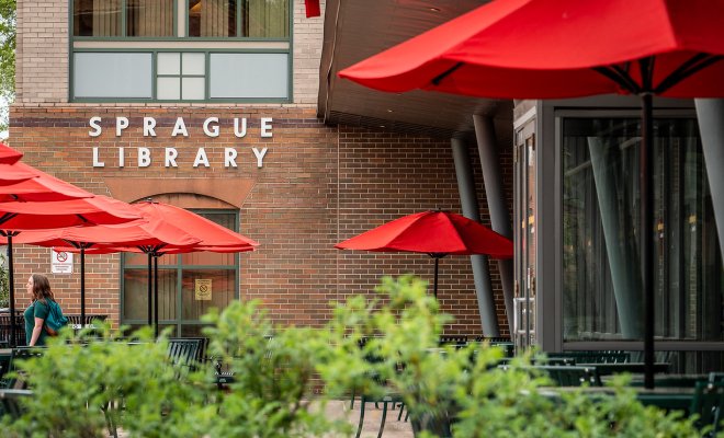 sprague library entrance with tables and umbrellas