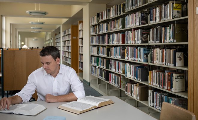 Jeffrey Miller researching texts in the Harry A Sprague Library.