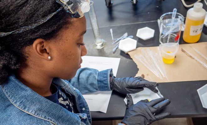 Student in laboratory running tests on a sample