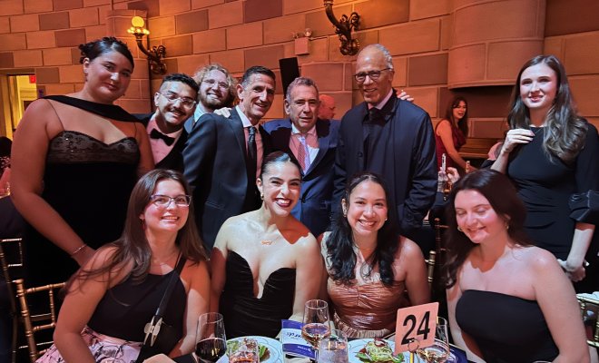 A group of Edward R. Murrow Awards Gala attendees pose at a dining table.