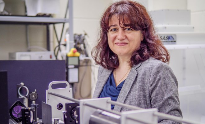 Rodica Martin standing by equipment in Physics lab