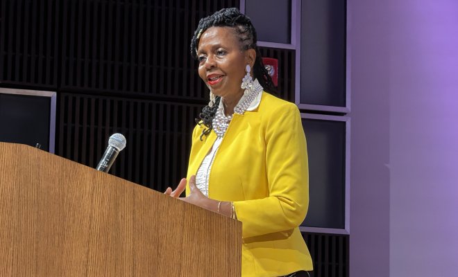 Donna Walker-Kuhne speaking at a podium for Peak Performances