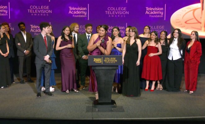 Dani Mazariegos, a senior majoring in Journalism and Digital Media, stands on stage accepting the Seymour Bricker Humanitarian Award on behalf of the Arizona Stories team at the 44th College Television Awards in Los Angeles. She is surrounded by 13 fellow student journalists, all dressed in formal evening attire, celebrating their win.