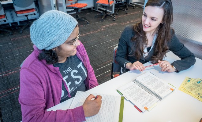 two students chatting and writing