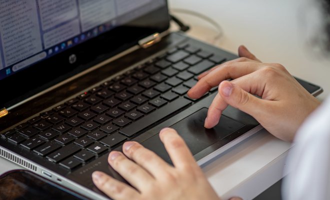 close up of person typing on a laptop