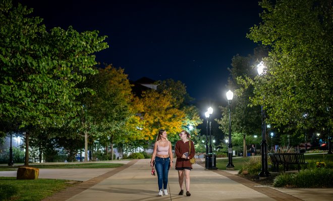 two students walking on campus at night