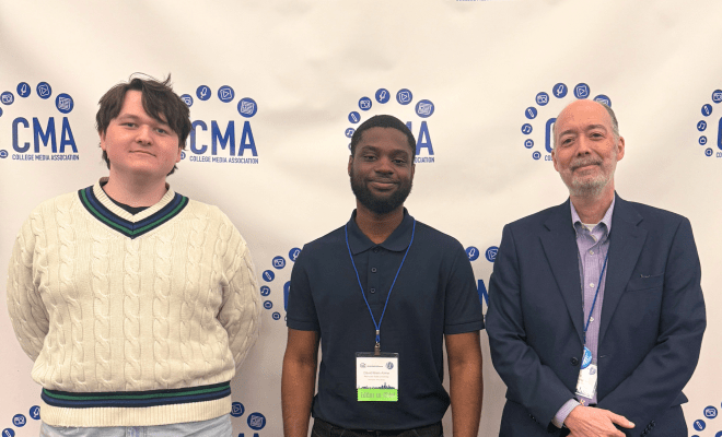 Students and advisor pose for a photo in front a step-and-repeat.