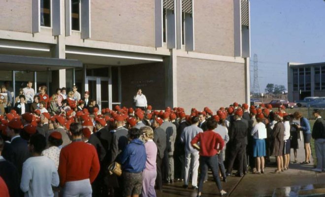 a large crowd of students wearing dink hats