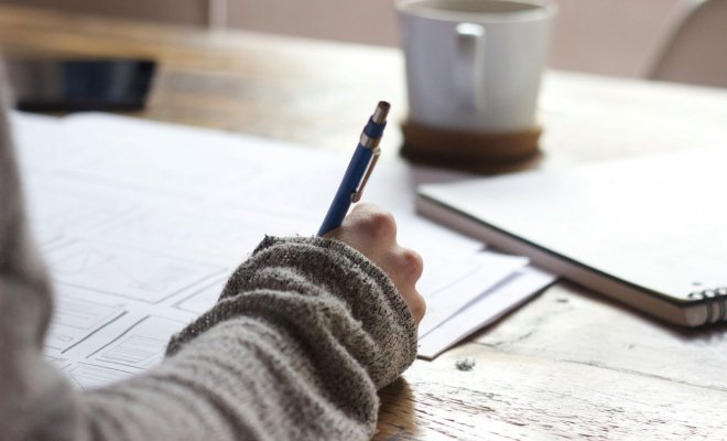 A hand holding a pen and writing