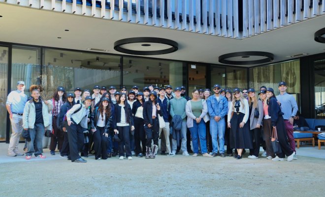 Group of students standing in front of a company entrance
