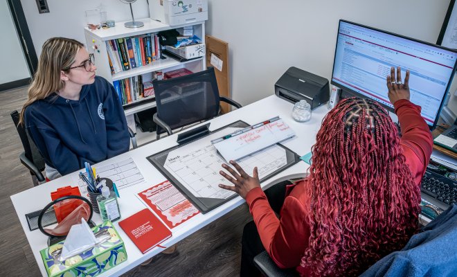 Advisor Helping Student at a desk