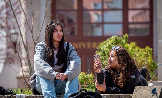 students talking on university hall steps