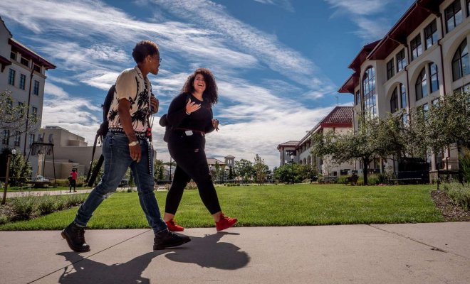 two students walking on campus together 